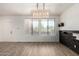 Bright living room features modern light fixture, luxury vinyl plank flooring, and large windows at 21655 N 36Th Ave # 131, Glendale, AZ 85308