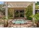Backyard retreat featuring a hot tub under a pergola and privacy landscaping at 2256 S Las Flores --, Mesa, AZ 85202