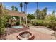 Charming backyard featuring a fire pit, jacuzzi, pergola, and lush desert landscaping at 2256 S Las Flores --, Mesa, AZ 85202