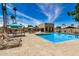 Community pool area showcasing ample deck space, lounge seating, shade, and a welcoming clubhouse at 2256 S Las Flores --, Mesa, AZ 85202