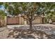 Exterior of tan brick home featuring a large tree shading the front yard at 2256 S Las Flores --, Mesa, AZ 85202
