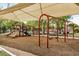 Community playground with swings, slides, and other fun activities for children under a sun shade at 2256 S Las Flores --, Mesa, AZ 85202