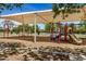 Community playground with swings, slides, and climbing structures under a large shade at 2256 S Las Flores --, Mesa, AZ 85202