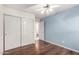 Bedroom with wood floors, ceiling fan, and closet, offering ample space and comfort at 2615 N 123Rd Dr, Avondale, AZ 85392