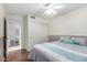 Comfortable bedroom with wood floors, a ceiling fan, and a view through the en suite bath at 2615 N 123Rd Dr, Avondale, AZ 85392