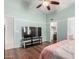 Bedroom with ceiling fan, wood floors, and television set, offers comfort and convenience at 2615 N 123Rd Dr, Avondale, AZ 85392