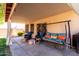 Relaxing covered patio with comfortable seating, swing, and a view of the landscaped backyard at 2615 N 123Rd Dr, Avondale, AZ 85392