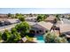Aerial view of a well-maintained home featuring a pool, covered patio, and lush backyard in a quiet residential neighborhood at 2615 N 123Rd Dr, Avondale, AZ 85392