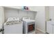 Bright laundry room with white washer, dryer, sink and shelving at 2741 E Odessa St, Mesa, AZ 85213