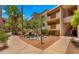 Exterior view of the residence shows balconies, stairs, and lush greenery with accent pond at 3031 N Civic Center Plz # 355, Scottsdale, AZ 85251