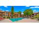 Community pool surrounded by lounge chairs, lush landscaping, and well-maintained building exteriors at 3031 N Civic Center Plz # 355, Scottsdale, AZ 85251