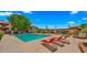 Community pool surrounded by lush greenery and comfortable lounge chairs on a sunny day at 3031 N Civic Center Plz # 355, Scottsdale, AZ 85251