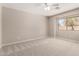 Simple bedroom with plush carpeting, neutral walls, and a large window at 30601 N Royal Oak Way, San Tan Valley, AZ 85143