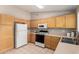 Charming kitchen with white appliances, tile flooring, and plenty of cabinet space at 30601 N Royal Oak Way, San Tan Valley, AZ 85143