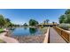Beautiful community pond with a bridge leading to a lakeside building, surrounded by lush greenery and rocks at 3307 E Kings Ave, Phoenix, AZ 85032