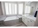 Bathroom featuring a sunken tub, white cabinets, and natural light at 3314 E Page Ave, Gilbert, AZ 85234