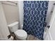 Bathroom featuring toilet, shower with blue patterned curtain, and tiled walls at 3314 E Page Ave, Gilbert, AZ 85234