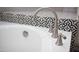 Modern bathtub with elegant faucet and decorative black and white tile surround adds a touch of sophistication at 3314 E Page Ave, Gilbert, AZ 85234