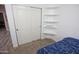 Cozy bedroom with carpet, closet with sliding doors, and display shelves at 3314 E Page Ave, Gilbert, AZ 85234