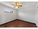 Neutral bedroom features a ceiling fan, small window, and stained concrete floors at 3814 E Poinsettia Dr, Phoenix, AZ 85028