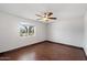 Neutral bedroom features a ceiling fan, small window, and stained concrete floors at 3814 E Poinsettia Dr, Phoenix, AZ 85028
