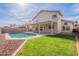 Inviting backyard featuring a pool, green lawn, and a charming two-story house with balcony at 3837 E Windsong Dr, Phoenix, AZ 85048