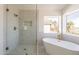 Contemporary bathroom featuring a glass shower and freestanding tub with a window view at 3837 E Windsong Dr, Phoenix, AZ 85048