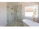 Clean bathroom featuring a glass shower and freestanding tub with a window view at 3837 E Windsong Dr, Phoenix, AZ 85048