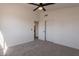 Cozy bedroom with carpet flooring, ceiling fan, a double door closet, and a single door at 3837 E Windsong Dr, Phoenix, AZ 85048