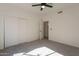 Cozy bedroom with plush carpeting, a ceiling fan, and a spacious closet with sliding doors at 3837 E Windsong Dr, Phoenix, AZ 85048