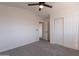 Bright bedroom featuring carpet flooring, ceiling fan, a closet, and a single door at 3837 E Windsong Dr, Phoenix, AZ 85048