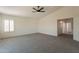 Carpeted bedroom featuring neutral walls, a ceiling fan, and an open doorway at 3837 E Windsong Dr, Phoenix, AZ 85048
