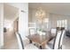Bright dining area with view of entryway features wooden table, modern light fixture, and neutral colors at 3837 E Windsong Dr, Phoenix, AZ 85048