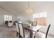 Dining room with wooden table, six chairs, view to living room, and modern light fixture at 3837 E Windsong Dr, Phoenix, AZ 85048