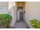 Inviting entryway featuring a secure screen door and lush greenery surrounding the entrance at 3837 E Windsong Dr, Phoenix, AZ 85048
