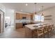 Open kitchen with center island featuring bar stool seating, stainless appliances, and modern light fixtures at 3837 E Windsong Dr, Phoenix, AZ 85048