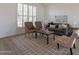 Inviting living room with plush seating, bright windows, and wood-look tile flooring at 3837 E Windsong Dr, Phoenix, AZ 85048