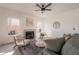 Bright living room featuring a fireplace, ceiling fan, and comfortable seating with lots of natural light at 3837 E Windsong Dr, Phoenix, AZ 85048