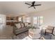 Bright living room with backyard views, a cozy fireplace, ceiling fan, and comfortable seating at 3837 E Windsong Dr, Phoenix, AZ 85048