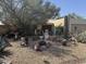 Southwest home featuring desert landscaping with rocks, cacti, and mature trees in a xeriscaped front yard at 401 W Cape Royal Ln, Phoenix, AZ 85023