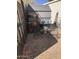 Side yard with gravel, wrought iron furniture, and metal shelving for plants and pots at 401 W Cape Royal Ln, Phoenix, AZ 85023
