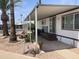 Charming single-story home featuring a covered porch, landscaped yard, and mature trees at 4065 E University Dr # 155, Mesa, AZ 85205