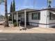 Charming single-story home featuring a covered porch, landscaped yard, and mature trees at 4065 E University Dr # 155, Mesa, AZ 85205