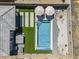 Aerial view of a backyard featuring a pool, hot tub, artificial grass, and lounge area at 40848 W Hillman Dr, Maricopa, AZ 85138