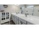 Bright bathroom featuring a double sink vanity with white countertops and a glass-enclosed shower at 40848 W Hillman Dr, Maricopa, AZ 85138