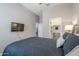 Bedroom featuring a walk-in closet, ensuite bathroom, neutral walls and a TV at 40848 W Hillman Dr, Maricopa, AZ 85138