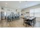 Bright open-concept dining room is adjacent to a modern kitchen with stainless appliances and an island at 40848 W Hillman Dr, Maricopa, AZ 85138
