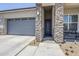Single-story home with stone accents, a two-car garage, and a welcoming walkway leading to the front door at 40848 W Hillman Dr, Maricopa, AZ 85138