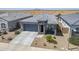 Aerial view of a single-story home boasting stone accents, low-maintenance landscaping, and a two-car garage at 40848 W Hillman Dr, Maricopa, AZ 85138
