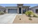 Attractive single-story home with a stone pillar entry, two-car garage, and desert landscaping at 40848 W Hillman Dr, Maricopa, AZ 85138